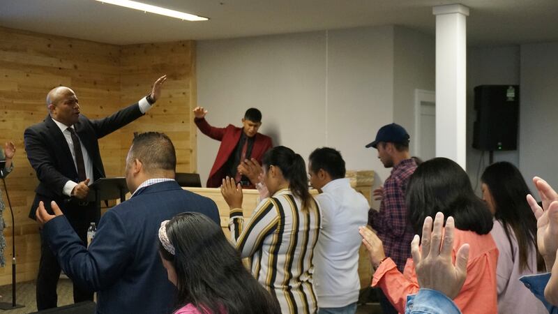 The Rev. Gustavo Castillo leads in song and praise members of his congregation at the Iglesia...