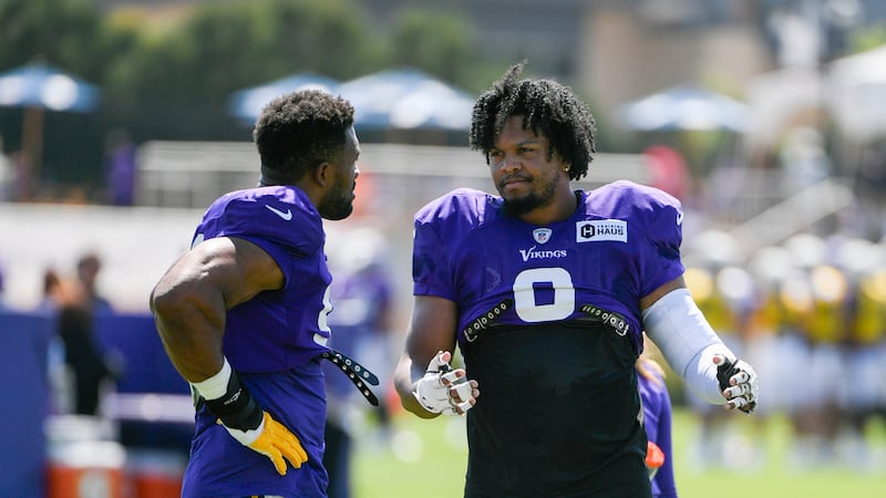 Minnesota Vikings linebacker Marcus Davenport, right, talks with linebacker Danielle Hunter...