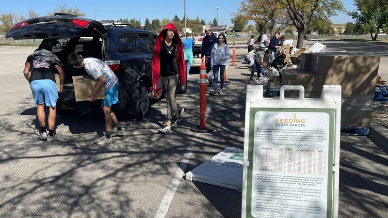 Students from Creekside Christian School in Rapid City help pack groceries into the trunks of...