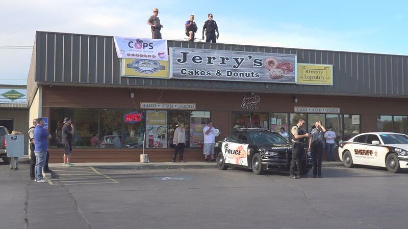 Law enforcement officers stood on Jerry's Cakes and Donuts to welcome customers into the shop.