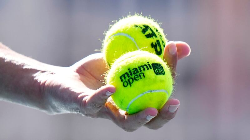 Taro Daniel, of Japan, selects his balls as he prepares to serve Emil Ruusuvuori, of Finland,...