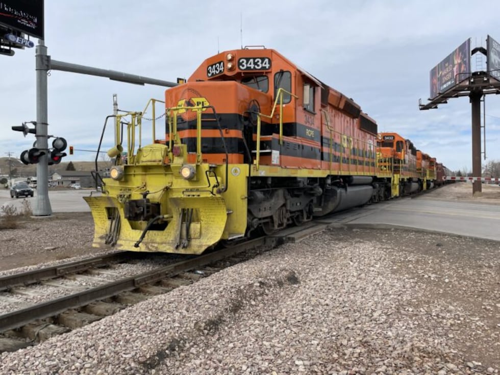 A train engine operated by the Rapid City, Pierre & Eastern Railroad trudges slowly through a...